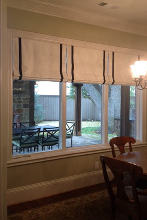 Roman shades over window overlooking back yard