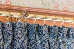 Elegant curtain rod and rings supporting custom drapery in Dallas