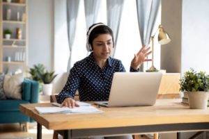 Woman in home office with window treatments in Dallas in the background