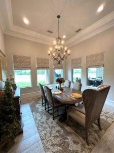 Elegant dining room with Roman shades on the windows